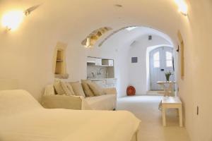 a white living room with a couch and a table at Axion Studios in Aroniadika