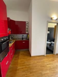 a red kitchen with red cabinets and a bathroom at Apartment Navigli Milano in Milan