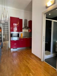 a kitchen with red cabinets and a hard wood floor at Apartment Navigli Milano in Milan +13 photos