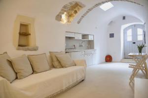 a white living room with a couch and a kitchen at Axion Studios in Aroniadika