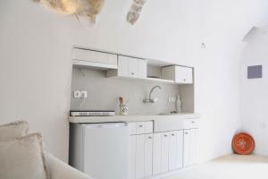 a white kitchen with a sink and a dishwasher at Axion Studios in Aroniadika