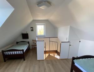 Cette chambre mansardée comprend un lit et une fenêtre. dans l'établissement Ferienwohnung II, à Schnelldorf