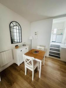 a white room with a table and chairs and a window at Le Cosy au cœur de Brétigny in Brétigny-sur-Orge