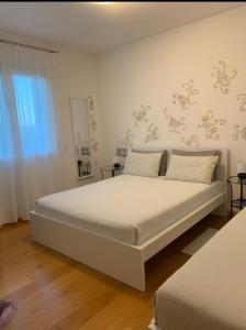 a bedroom with a large white bed and a window at B&B Beauty House in Cesena