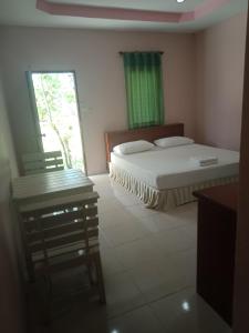 een slaapkamer met een bed, een raam en een stoel bij เรือนแสนรัก รีสอร์ท in Ban Nong Ket Yai