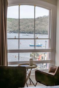 a room with a large window with a view of the water at The King in Fowey