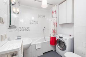 a white bathroom with a washing machine in it at Miedziana 14 by Homeprime in Warsaw
