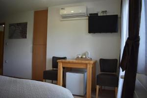 a room with a table and two chairs and a television at Plitvice House Rosha 2 in Plitvička Jezera