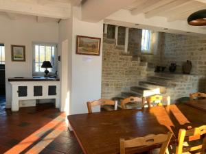 a dining room with a wooden table and a brick wall at Gîte de groupe agritourisme 3 gîtes mitoyens 25 couchages Convivialité et intimité in Lingèvres