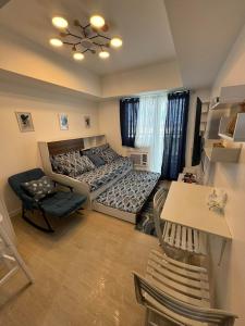 een slaapkamer met een bed en een tafel en stoelen bij Gellybean Homestay ( AZURE North Residence / Staycation) in San Fernando