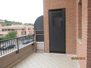 eine schwarze Tür an der Seite eines Backsteingebäudes in der Unterkunft casa fiano in Fiano Romano