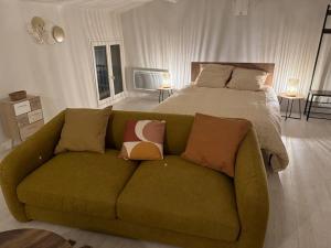 a green couch in a bedroom with a bed at Carpentras cosy& 3 voyageurs& in Carpentras