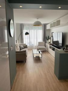 ein Wohnzimmer mit einem Sofa und einem Tisch in der Unterkunft Appartement lumineux proche Paris in Châtillon