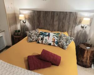 a yellow bed with pillows on top of it at Au coeur d'un cocon.... in Pennautier