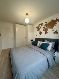 ein Schlafzimmer mit einem großen Bett mit einer Karte an der Wand in der Unterkunft Appartement lumineux proche Paris in Châtillon