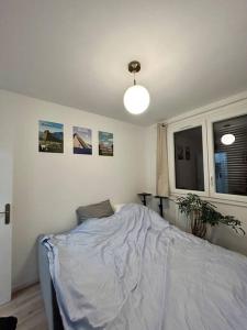 ein Schlafzimmer mit einem Bett mit einer weißen Decke darauf in der Unterkunft Appartement lumineux proche Paris in Châtillon