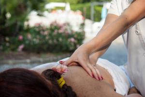 una donna che si fa fare un massaggio in piscina di Il Cigliere Wellness Spa Resort a Riparbella
