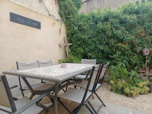 a table and chairs with a sign on a wall at Au coeur d'un cocon.... in Pennautier