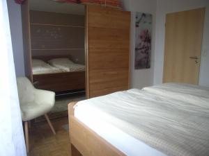een slaapkamer met een bed en een dressoir met een kast bij Obst- Und Ferienhof Marschall in Wasserburg