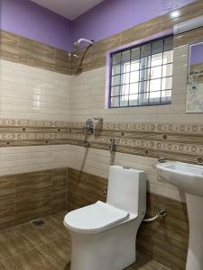 ein Bad mit einem WC und einem Waschbecken in der Unterkunft Hotel Mangalam in Siddharthanagar