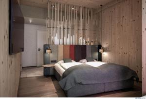 a bedroom with a large bed and a chandelier at Mariengut - Natur Aparthotel Kramer in Wagrain