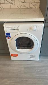 a washing machine with a hat on top of it at BELMAYNE APARTMENTS in Dublin