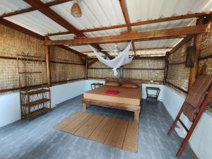 Zimmer mit einem Bett und einer Hängematte. in der Unterkunft KAMAKU Bungalows in Koh Rong Sanloem