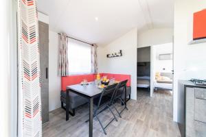 a dining room with a table and chairs in a room at Camping het Wieskamp in Henxel