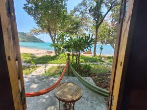 a porch with a hammock and a view of the beach at KAMAKU Bungalows in Koh Rong Sanloem