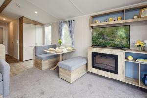 een woonkamer met een open haard en een televisie bij Ingoldale Holiday Park in Ingoldmells
