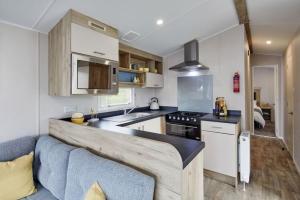 cocina con armarios blancos y encimera en Ingoldale Holiday Park, en Ingoldmells