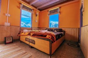 uma cama grande num quarto com duas janelas em Suhaana Ghar em Sainj