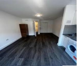 una stanza vuota con cucina e pavimento in legno massello di BELMAYNE APARTMENTS a Dublino