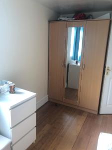 a bedroom with a dresser and a large mirror at London Homestay with big double room in London