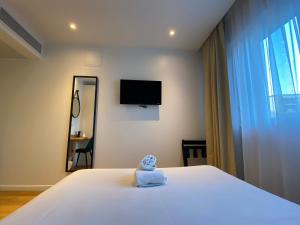 a bedroom with a bed with a towel on it at Oskar Hotel in Annemasse +39 photos