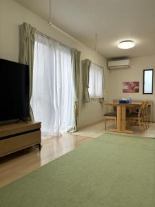 a living room with a television and a table at ゆうゆう八街新築4LDK free wifi in Yachimata
