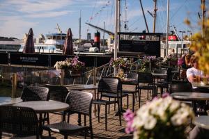 a group of tables and chairs on a patio with a marina at Husbåten Vega 1 Göteborg City in Gothenburg