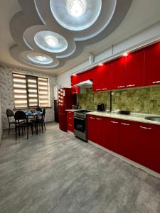 een grote keuken met rode kasten en een eettafel bij OS Rill in Samarkand