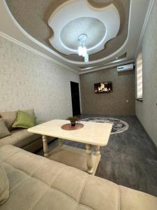 een woonkamer met een tafel en een bank bij OS Rill in Samarkand