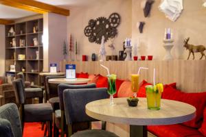 un restaurante con dos mesas con bebidas. en SOWELL HOTELS Le Parc & Spa, en Briançon