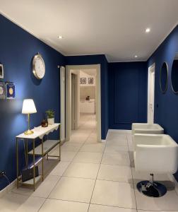 bagno con pareti blu, lavandino e specchio di Il Tenore B&B a Verona