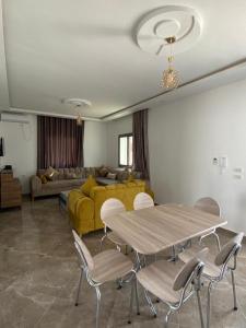 a living room with a table and chairs and a yellow couch at Maison de Noé Djerba Midoun in Midoun