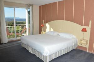 アルボンにあるBest Western Golf d'Albonのベッドとバルコニー付きのホテルルーム