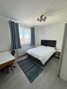Schlafzimmer mit einem Bett, einem Schreibtisch und einem Fenster in der Unterkunft Sunrise paradise in Suceava