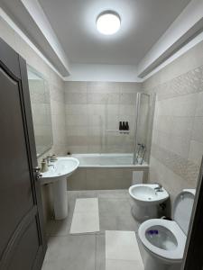 ein Badezimmer mit einem Waschbecken, einem WC und einer Badewanne in der Unterkunft Sunrise paradise in Suceava
