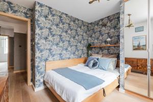 a bedroom with blue and white wallpaper and a bed at SuperApart Wspólna 27a, City Center in Warsaw