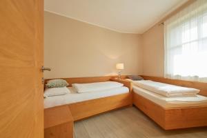 two beds in a room with a window at Landhaus Antonius in Appiano sulla Strada del Vino