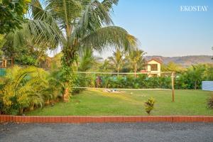a volley ball hoop in a yard with palm trees at EKOSTAY - Bloomfield Villa in Alibaug
