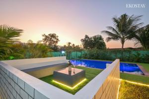 an image of a backyard with a swimming pool and a garden at EKOSTAY - Bloomfield Villa in Alibaug +20 photos