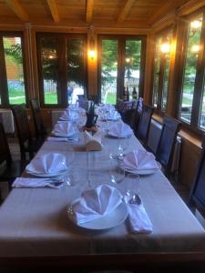 una mesa larga con vasos y servilletas. en Guest House Rilindja Valbone, en Valbonë